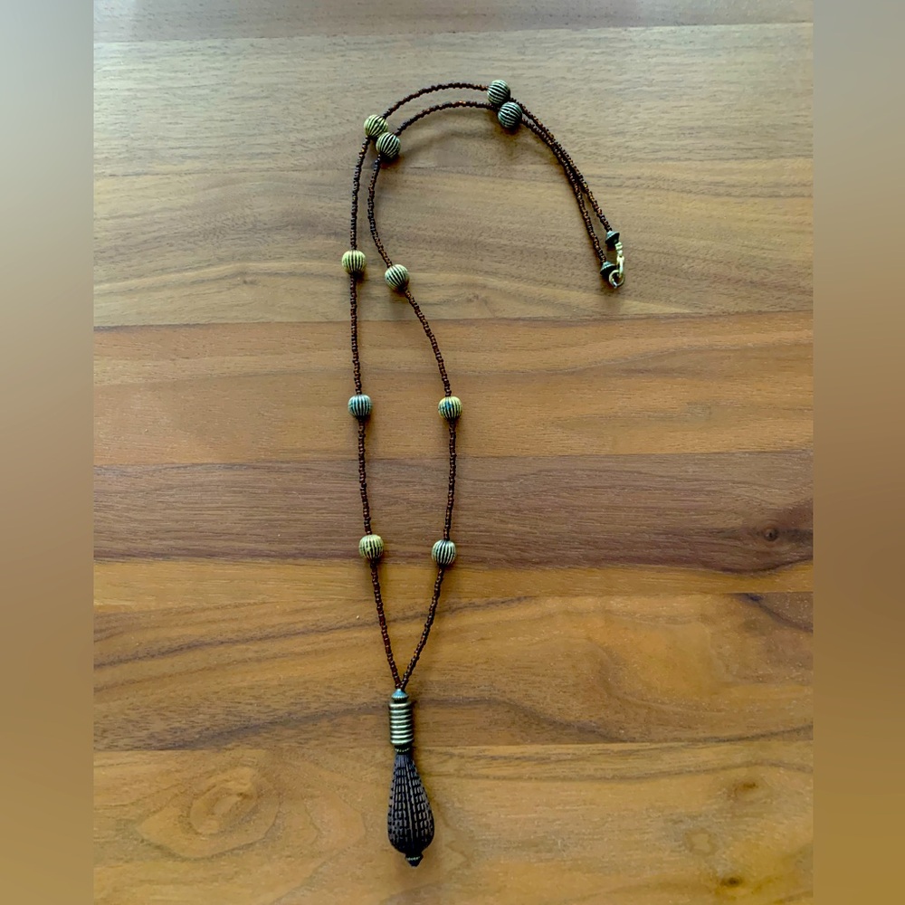 Necklace small brown glass beads, larger gold spheres. Hung w/ copper pendant.
